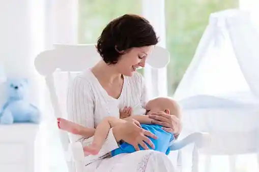 mom lovingly breastfeeding her newborn=